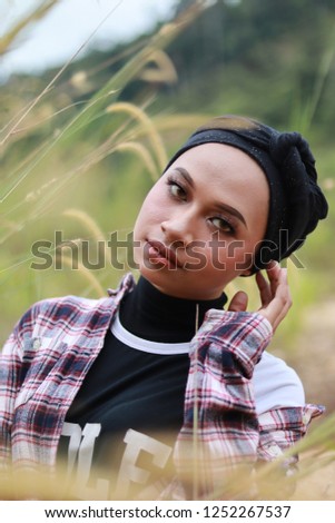 Beautiful portrait of Asian women in black turban and plaid shirt.