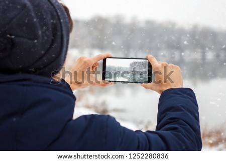 the guy takes pictures on the phone winter nature, hands taking pictures of winter nature, Hiking, the concept of winter recreation