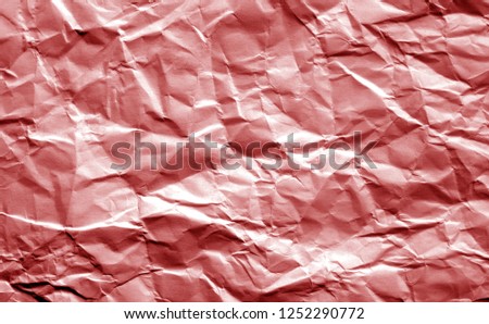 Crumpled sheet of paper in red color. Abstract background and texture for design.