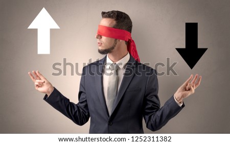 Covered eye businessman choosing between two directions 