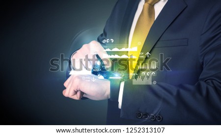 Businessman wearing smartwatch with graphics and charts on it.
