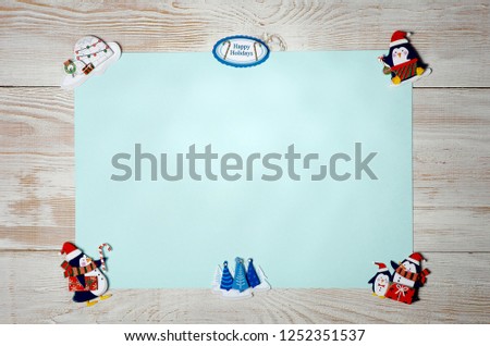 Christmas background of colored paper, snow, penguins and stickers. wooden background