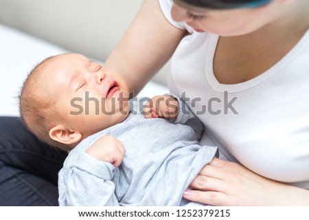newborn is crying because of colic pain Royalty-Free Stock Photo #1252379215