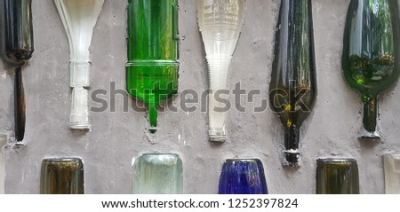 Colorful glass bottles cemented to a wall