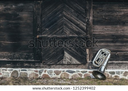 Old tuba on wooden wall background
