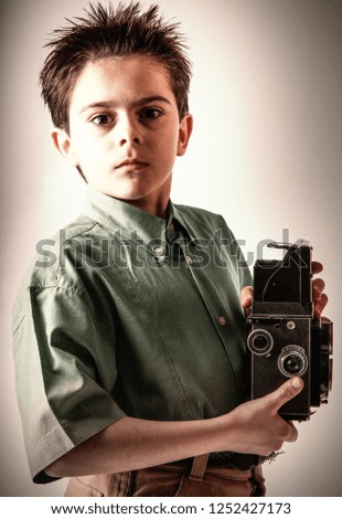 a Little boy with a vintage camera