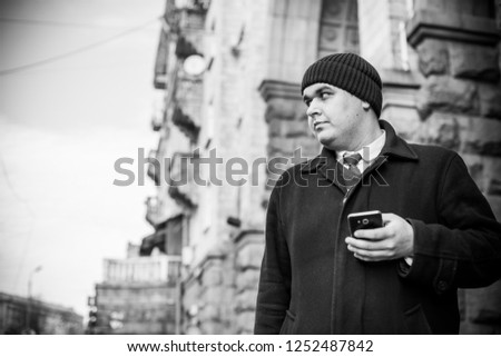 View of  plump guy using smartphone, Young urban businessman professional on smartphone walking in street using app texting sms message on smartphone