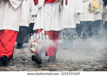 altar boys swirl vessels with incense on a procession on corpus christi in cologne