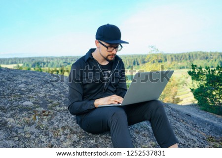 portrait of young traveler rock climber on the background of spellbinding landscape of Norwegian nature with high charming mountains and hills in which it is impossible not to fall in love work on lap