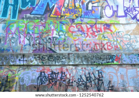 Fragment of graffiti tags. The old wall is spoiled with paint stains in the style of street art culture