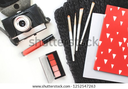top view working space with laptop, old retro camera, cup of coffee and cosmetics for Beauty and fashion designer,marble background. flatlay. Color of the year 2019 living coral