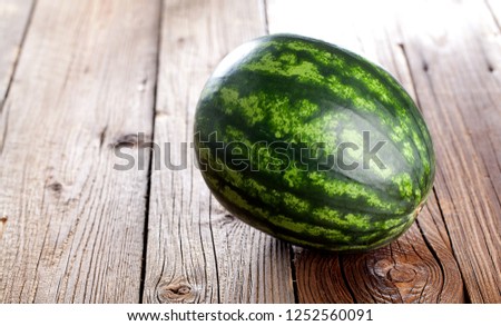 Fresh ripe striped sliced watermelon on wooden background