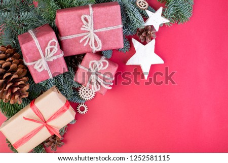 Christmas composition. Christmas red decorations, fir tree branches with toys gift boxes on red background. Flat lay, top view, copy space