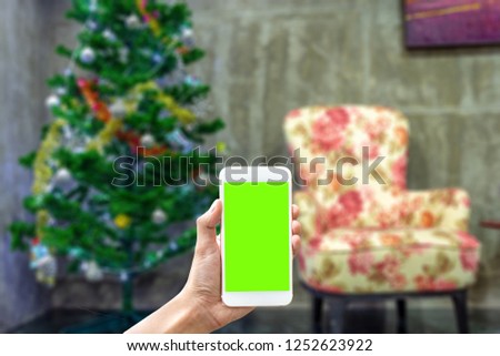 A man hand holding a smartphone on middle side to use application to reserve hotel resort or activity or shopping online on new year chrismas eve 2019 -  - can use for a apps with blurred background