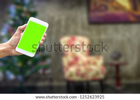 A man hand holding a smartphone on left side to use application to reserve hotel resort or activity or shopping online on new year chrismas eve 2019 -  - can use for a apps with blurred background