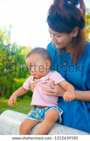 Asian female model and asian baby pose for pictures in the nature