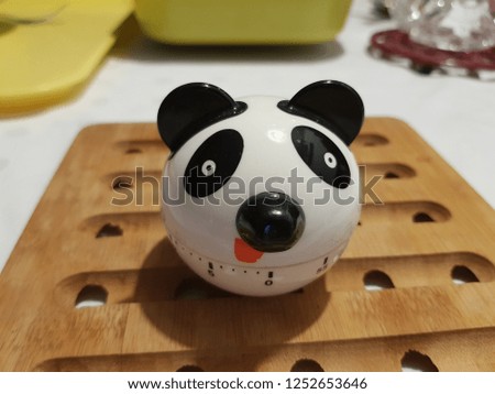 Plastic panda head shape cooking clock/timer on a wooden plate  