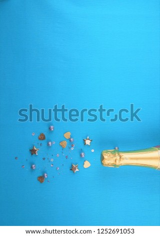 Creative concept photo of champagne bottle with confetti on  background.