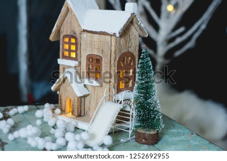 Christmas and winter decoration with light wooden house, white slide, fir tree and white little balls 