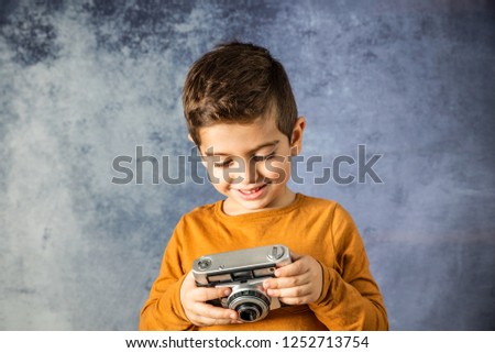 Portrait of young boy with a photographic camera