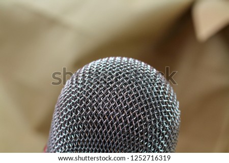 Microphone on the background of blurred paper carton