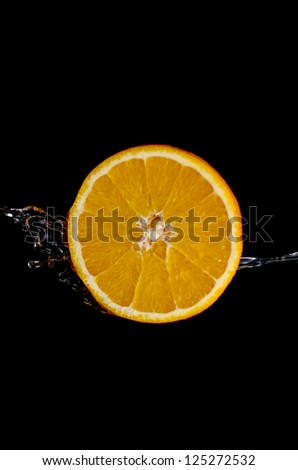 orange is dropped into water splash