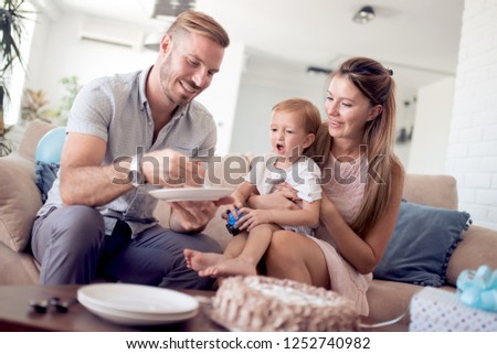 celebration, family, holidays and birthday concept - happy family with cake, dad feeds his son with birthday cake.