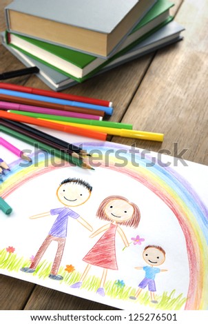 kids drawing happy family picture on the wooden table
