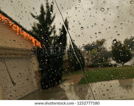 Blurry raindrops with house in the background.