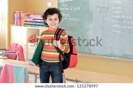 Student boy with a red backpack in the class