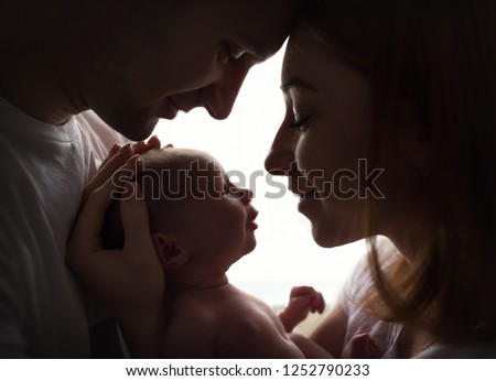 Happy family with newborn baby by the window Royalty-Free Stock Photo #1252790233
