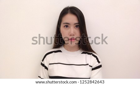 Asian girl is smiling and looking straight with white background