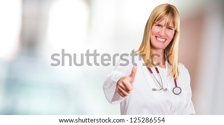 Female Doctor Showing Thumb Up against an abstract background