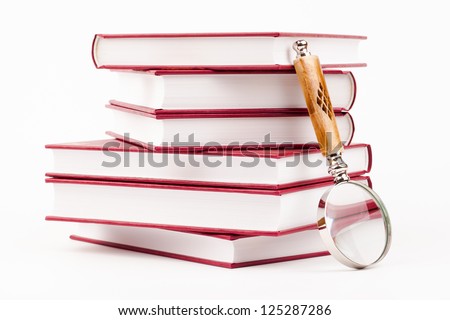 books and magnifying glass isolated on white
