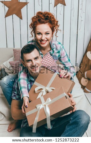 beautiful loving couple celebrates Christmas and New Year at home near the New Year tree with gifts, happy holiday on Christmas Eve, gifts, together, couple in love, winter, Smile Happiness, 2019