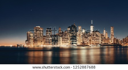 Downtown Manhattan skyline over East River at night in New York City