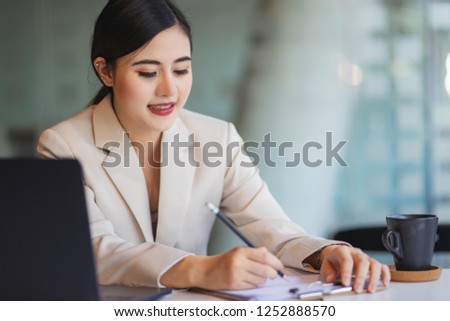 Young woman working at lap top in the office.