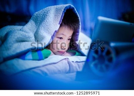 asian chinese boy playing smartphone on bed, watching smartphone, kid use phone and play game, child use mobile, addicted game and cartoon,