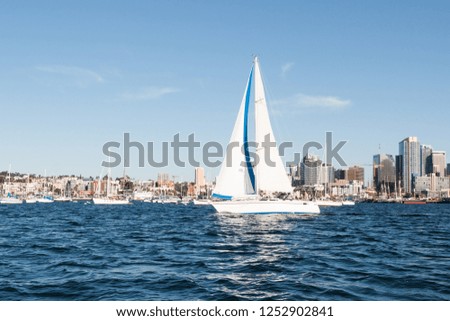 A sailboat in San Diego bay with the downtown skyline in the background.