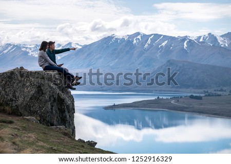 Couple enjoys beautiful scenery in New Zealand. Romantic couple smiling. A pair of couple goes on honeymoon in natural landscape. Leisure image of a young couple in happiness. Happy people on holiday. Royalty-Free Stock Photo #1252916329
