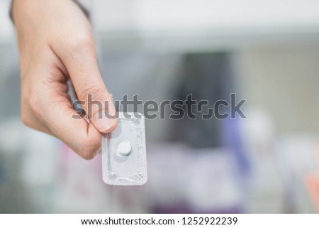 A hand holding emergency contraception (morning after pill) packs. Royalty-Free Stock Photo #1252922239