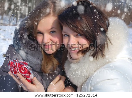 Two girls with a decorative heart in winter