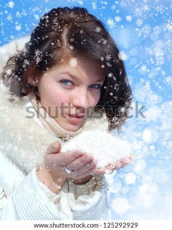 Girl in winter clothes blowing snow