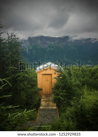 An outhouse with a mountain view. Royalty-Free Stock Photo #1252929835