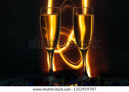 Two glasses of champagne and a background of fire or spark