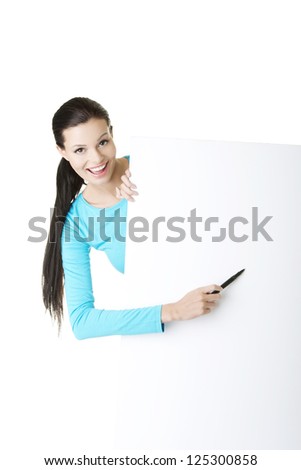 Happy beautiful woman writing with a pen on blank board. Student or businesswoman.