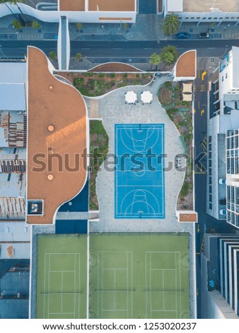 Basketball and and tennis court on city rooftop.