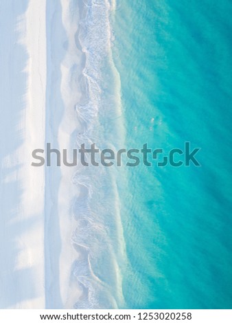 Calm sandy beach with cool blue ocean.