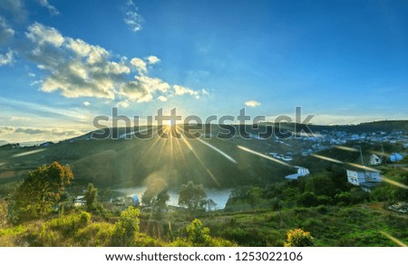 Dawn on plateau in morning with colorful sky, while sun rising from horizon shines down to small village landscape so beautiful idyllic countryside Dalat plateau, Vietnam