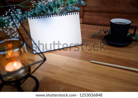 Flat lay of blank white notebook with cup coffee on wooden table. Copy space. ready for adding text or mockup. 